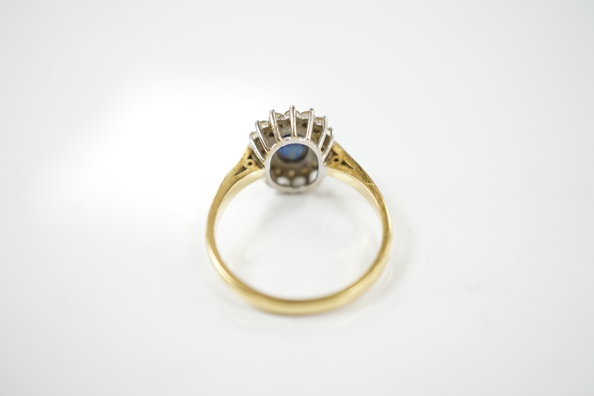 A modern 18ct gold, sapphire and diamond set oval cluster ring, size P/Q, gross weight 4.9 grams. Condition - fair